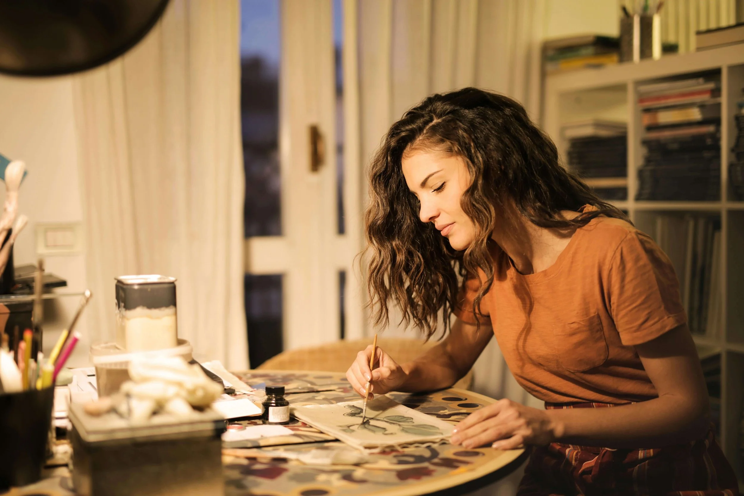 A woman with wavy brown hair painting green leaves with watercolor. If love triggers your anxiety, ERP therapy in Boston, MA can help you interrupt the cycle. Get started today with an OCD therapist.