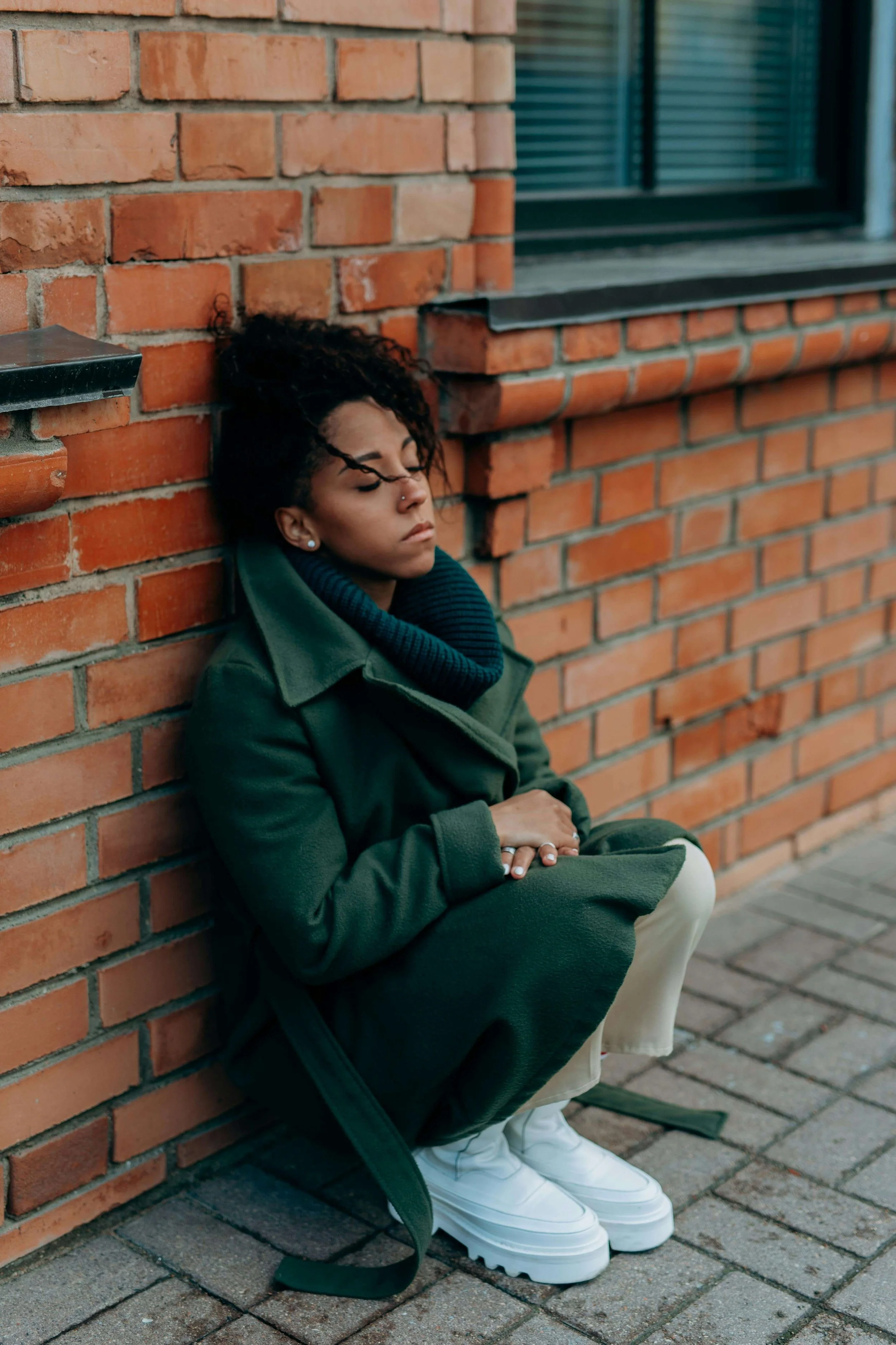 woman sitting against brick wall | ocd therapist boston ma | ocd counseling boston ma | online OCD therapy boston, ma | Cambridge, MA | Somerville, MA | Brookline
