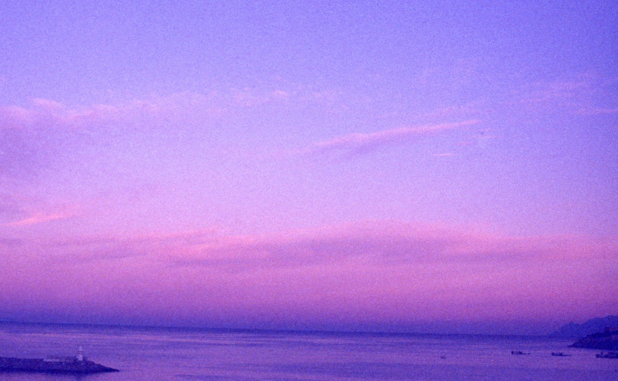 A purple hued photo of a beach with a lighthouse in the distance. Therapy for OCD in Boston, MA is here to support you with overthinking & harm OCD. Get started with an OCD therapist today.