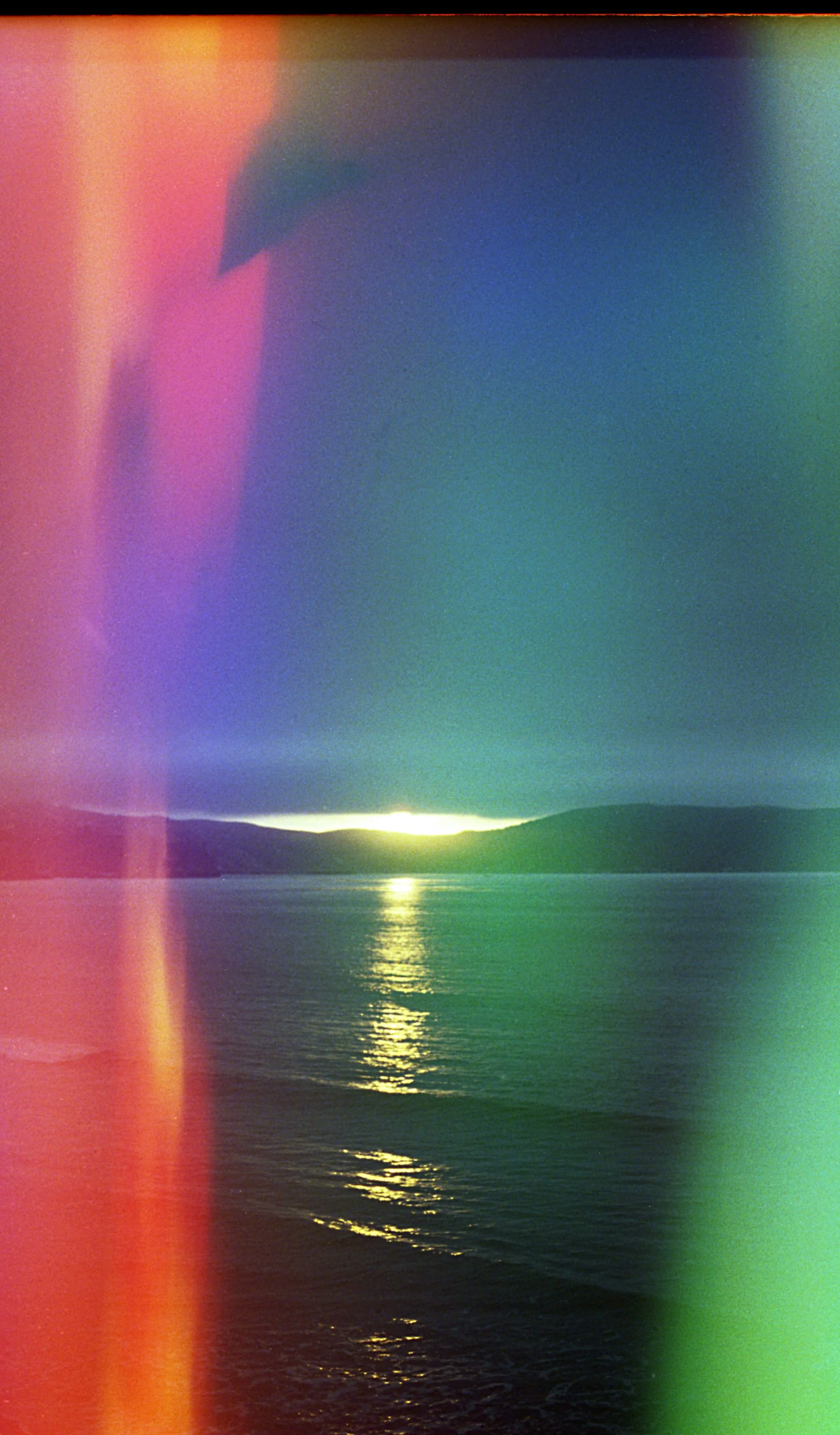 A colorful hued photo of water, sun & mountains. OCD counseling in Boston, MA & the Cambridge area can help you with learning practical mindfulness skills for OCD recovery. Learn more here.