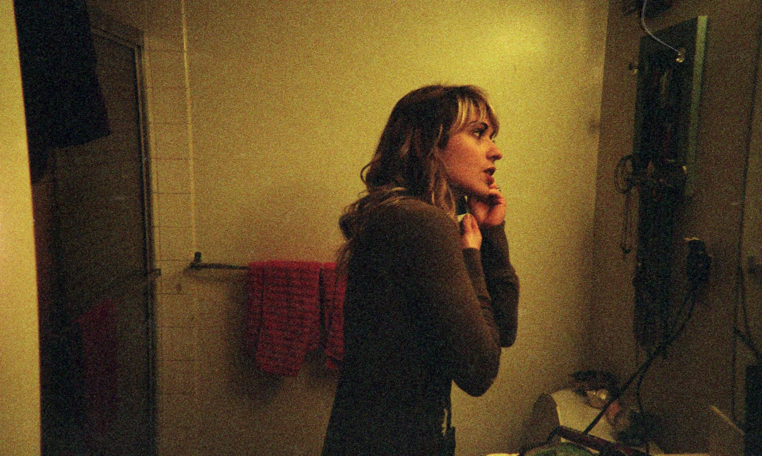A woman with blonde hair looking at herself in a mirror while getting ready. OCD counseling in Boston, MA can help you build a better relationship with overthinking & rumination. Reach out to an OCD therapist today.