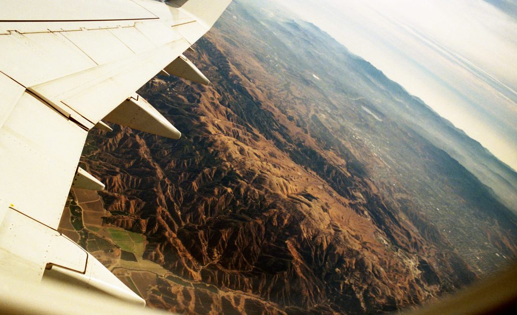 A view of beautiful mountains from an airplane window. An OCD therapist in San Diego, CA is here to support anyone navigating rumination, overthinking & uncertainty.
